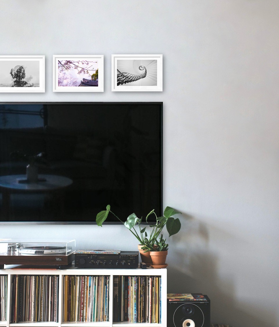 Three white picture frames in the size 21x30 above a TV