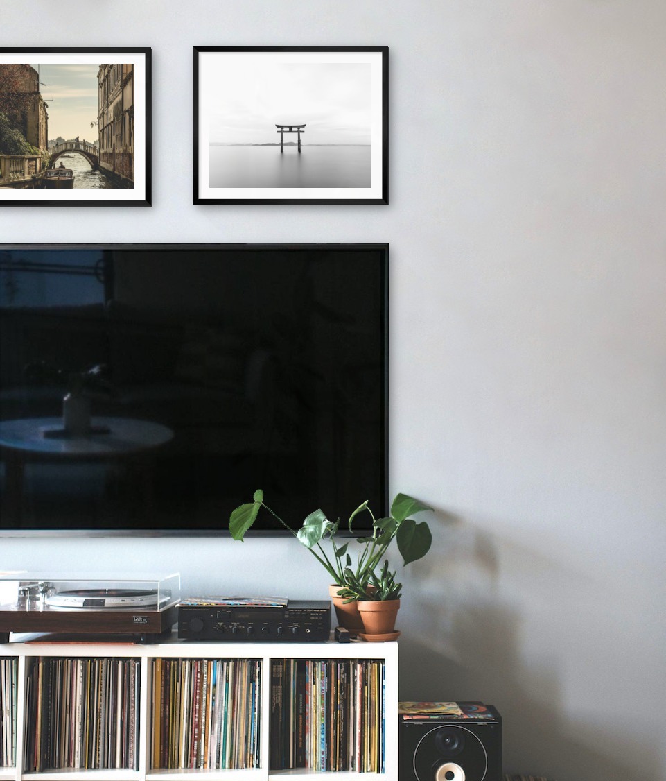 Two black picture frames in the size 40x50 above a TV
