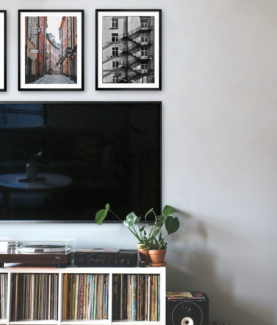 Three black picture frames in the size 40x50 above a TV