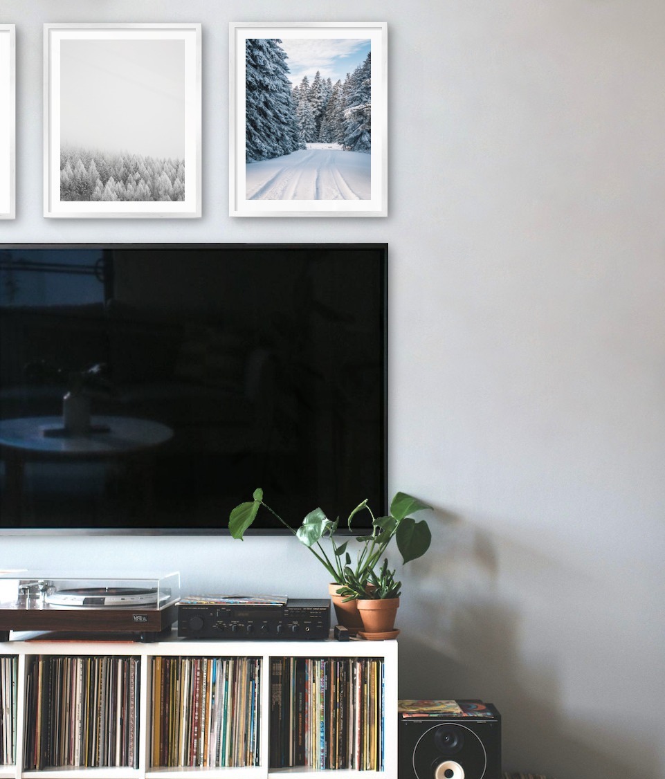 Three silver picture frames in the size 40x50 above a TV