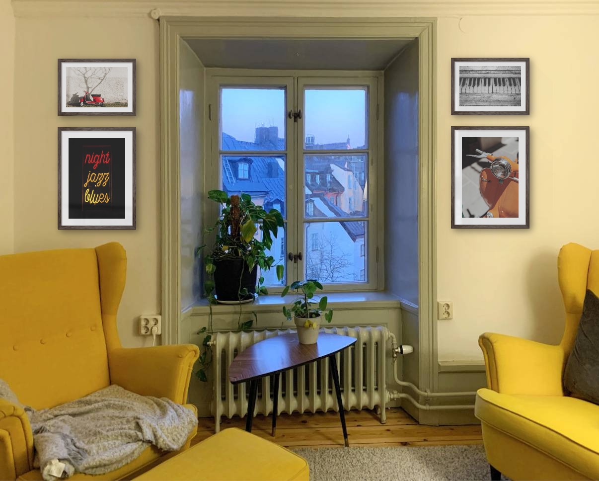 Four picture frames in dark wood in the sizes 21x30 and 30x40 around a window