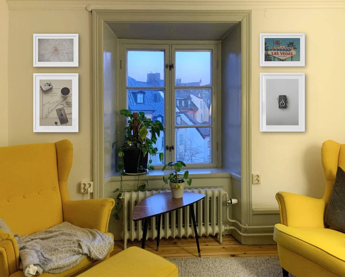Four picture frames in white in the sizes 21x30 and 30x40 around a window