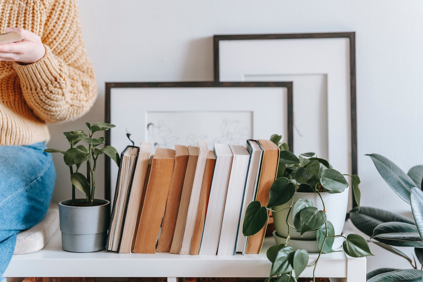 Image of a person sitting on a desk with empty picture frames