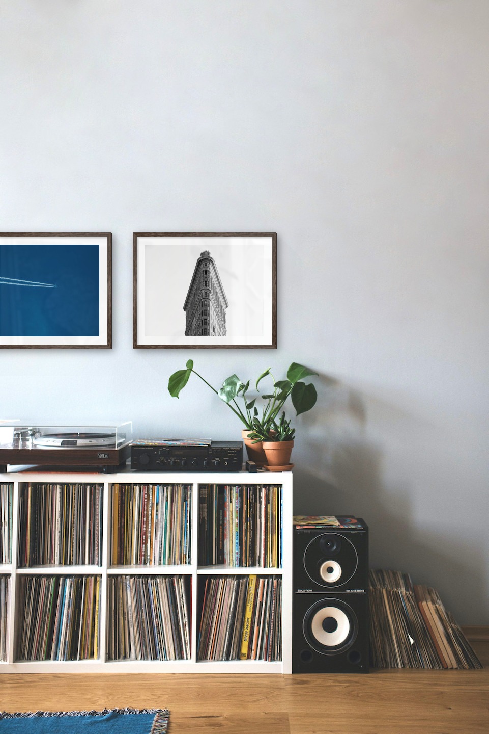 Gallery wall with picture frames in dark wood in sizes 40x50 with prints "Airplanes in the air" and "Triangular building"
