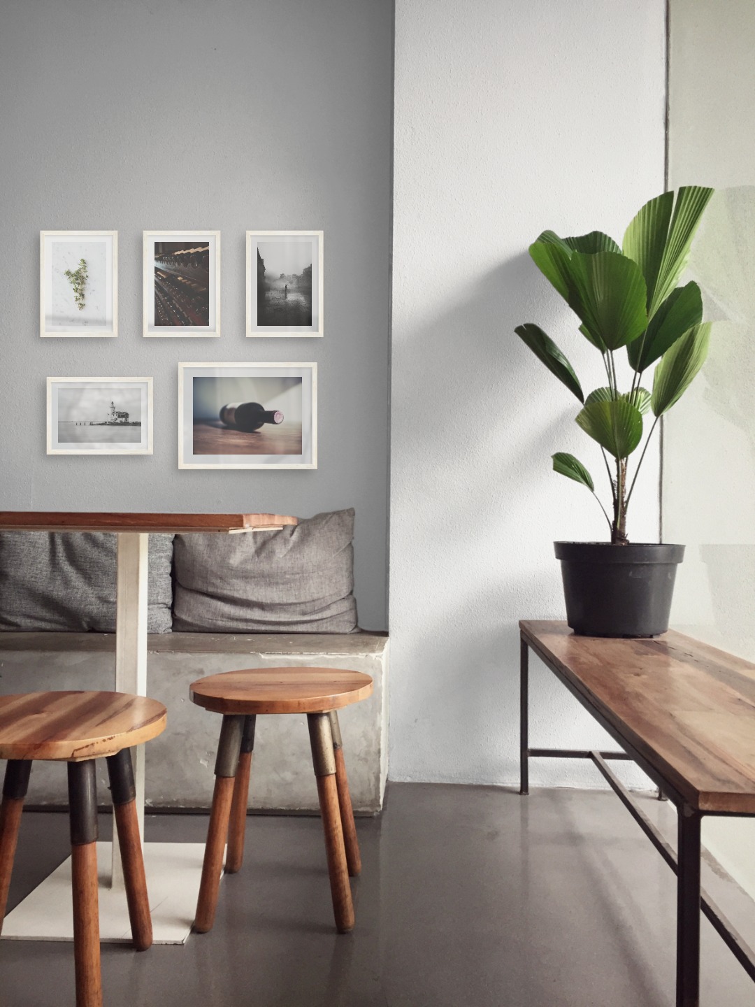 Gallery wall with picture frames in light wood in sizes 21x30 and 30x40 with prints "Herbs", "Wine storage", "Rainy city", "Pier with building" and "Wine bottle on table"