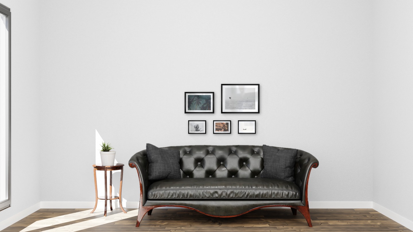Gallery wall with picture frames in black in sizes 21x30, 30x40 and 13x18 with prints "Palm trees and night sky", "Birds over the sea", "Trees and silhouette", "Clothes hangers" and "People in boat"