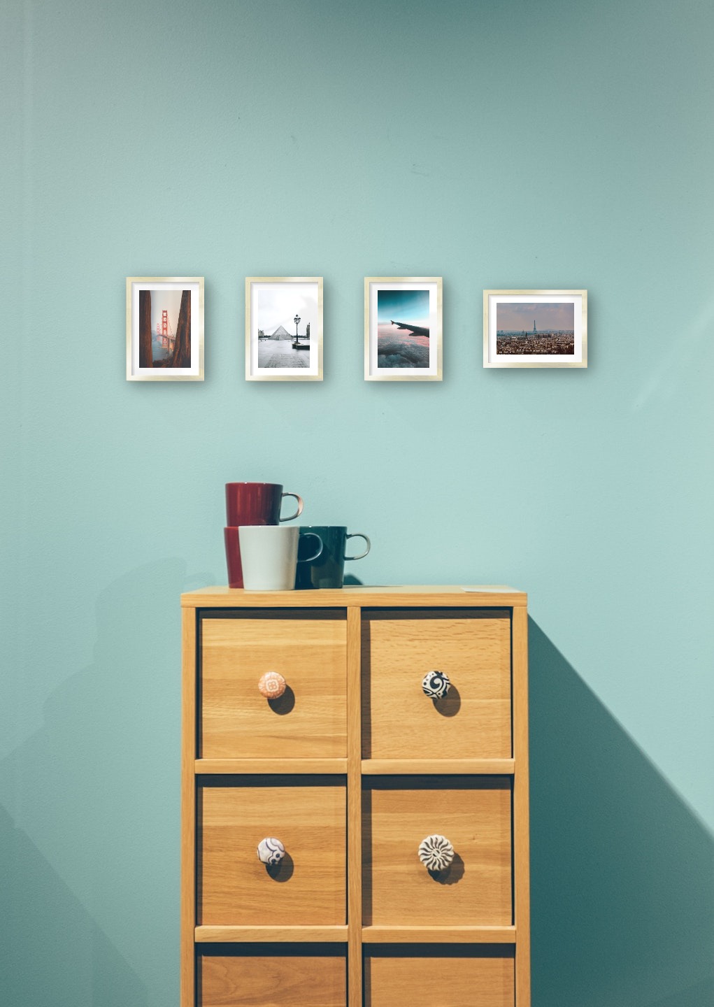 Gallery wall with picture frames in gold in sizes 13x18 with prints "Golden Gate Bridge", "Louvre in Paris", "Above the clouds" and "Eifel Tower in Paris"