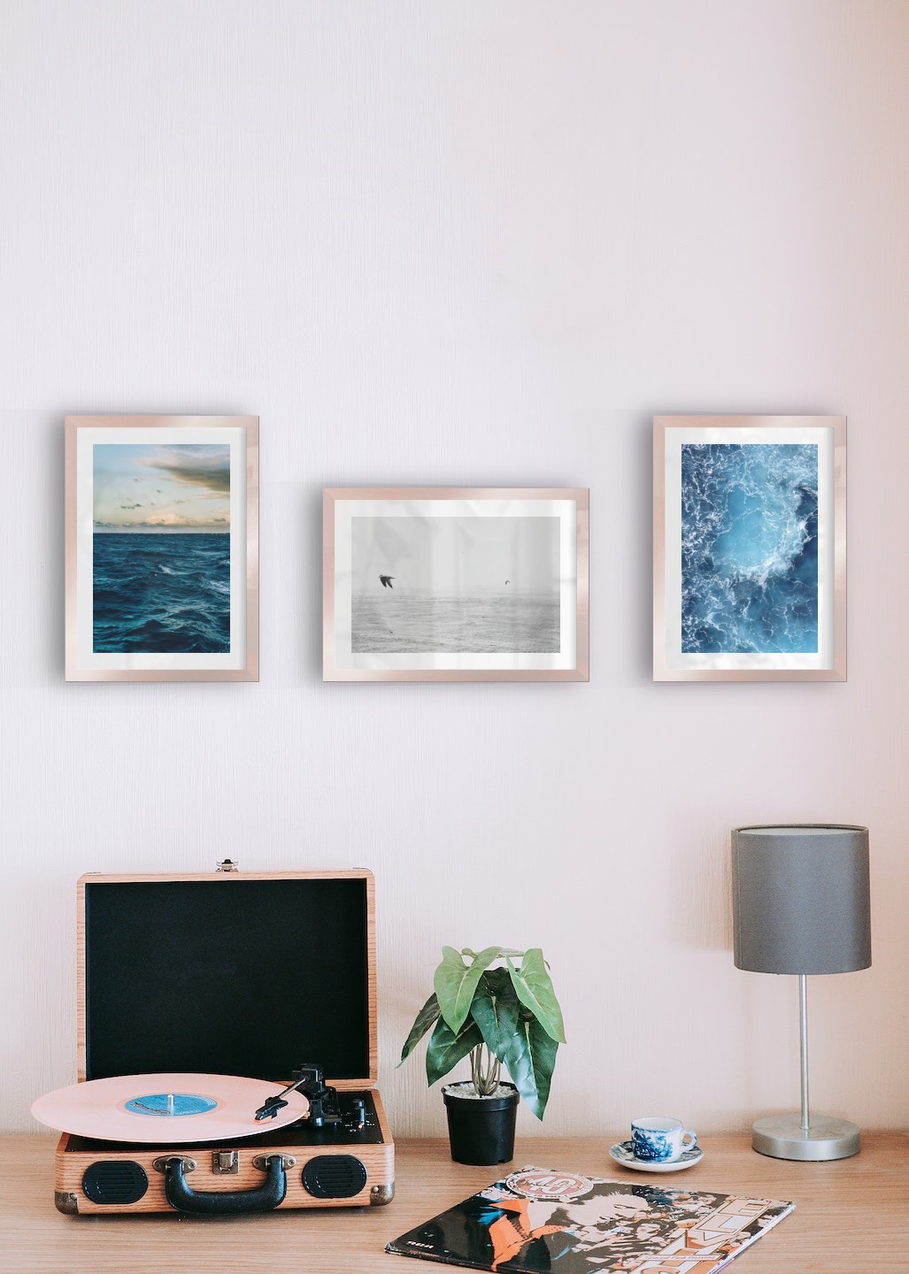 Gallery wall with picture frames in copper in sizes 21x30 with prints "Somewhat out at sea", "Birds over the sea" and "Sea from above"