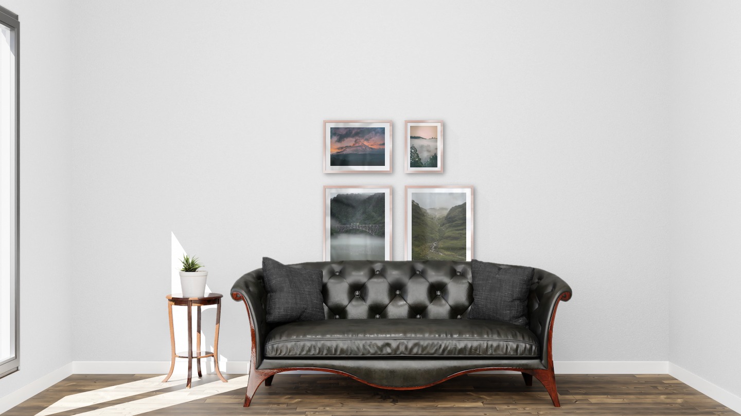 Gallery wall with picture frames in copper in sizes 40x50, 30x40 and 21x30 with prints "Train over bridge", "Stream in valley", "Sunset and mountains" and "Wooden tops and orange sky"