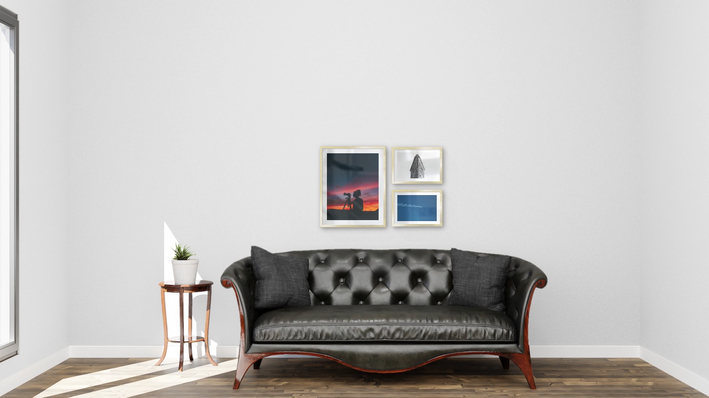 Gallery wall with picture frames in gold in sizes 40x50 and 21x30 with prints "Photographer at night", "Triangular building" and "Airplanes in the air"
