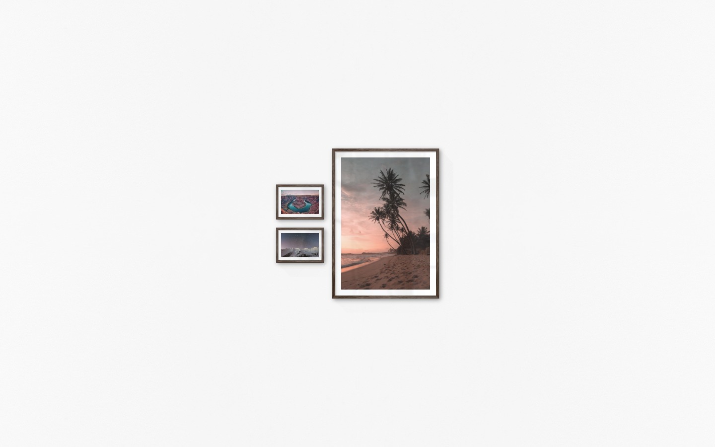 Gallery wall with picture frames in dark wood in sizes 21x30 and 70x100 with prints "Canyon", "Mountains with night sky" and "Beach at sunset"