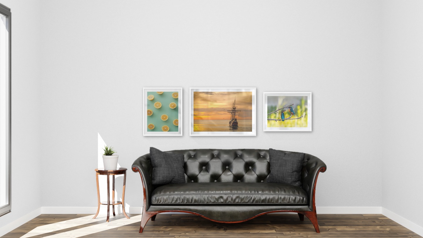 Gallery wall with picture frames in white in sizes 40x50 and 50x70 with prints "Lemons", "Ships at sea" and "Hummingbirds"
