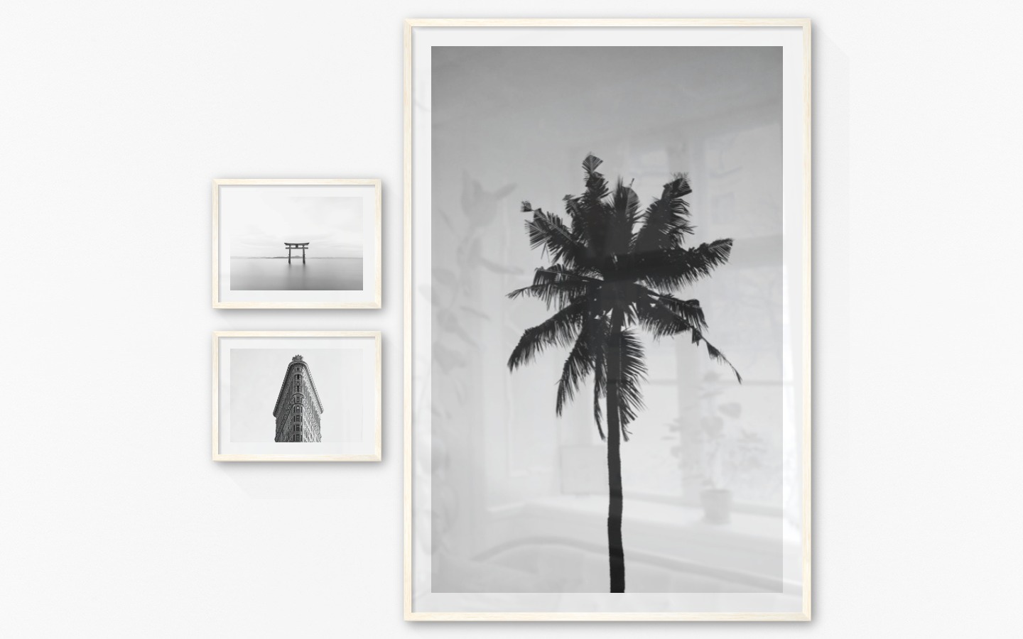 Gallery wall with picture frames in light wood in sizes 30x40 and 100x150 with prints "Pillars in the water", "Triangular building" and "Palm"