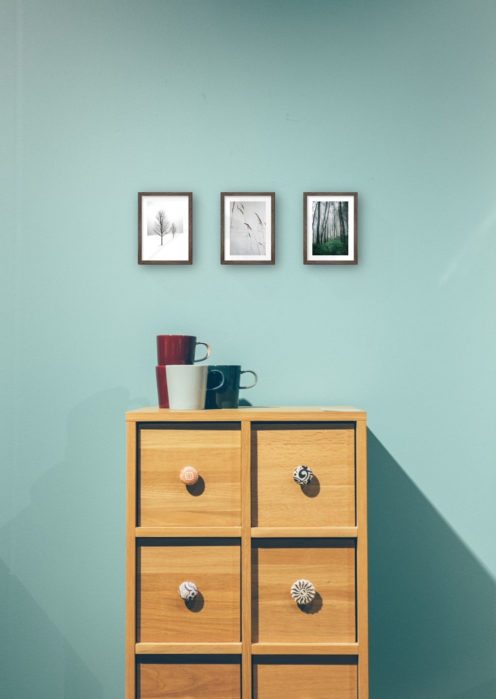 Gallery wall with picture frames in dark wood in sizes 13x18 with prints "Trees in the snow", "Sharp in the snow" and "Tall trees"
