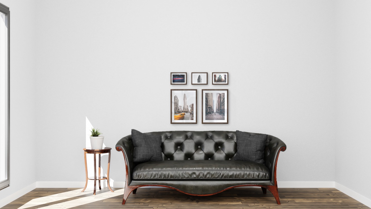 Gallery wall with picture frames in dark wood in sizes 30x40 and 13x18 with prints "Yellow taxis in town", "Man walking across the street", "Light on the way", "Triangular building" and "Street corner"