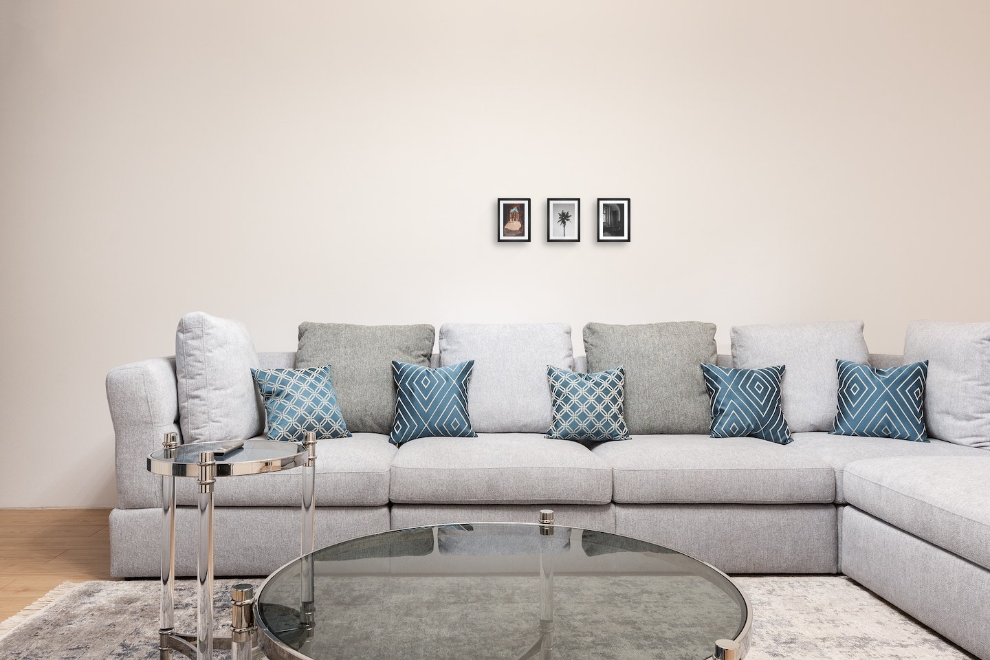 Gallery wall with picture frames in black in sizes 13x18 with prints "Petra in Jordan", "Palm" and "Chair in front of window"