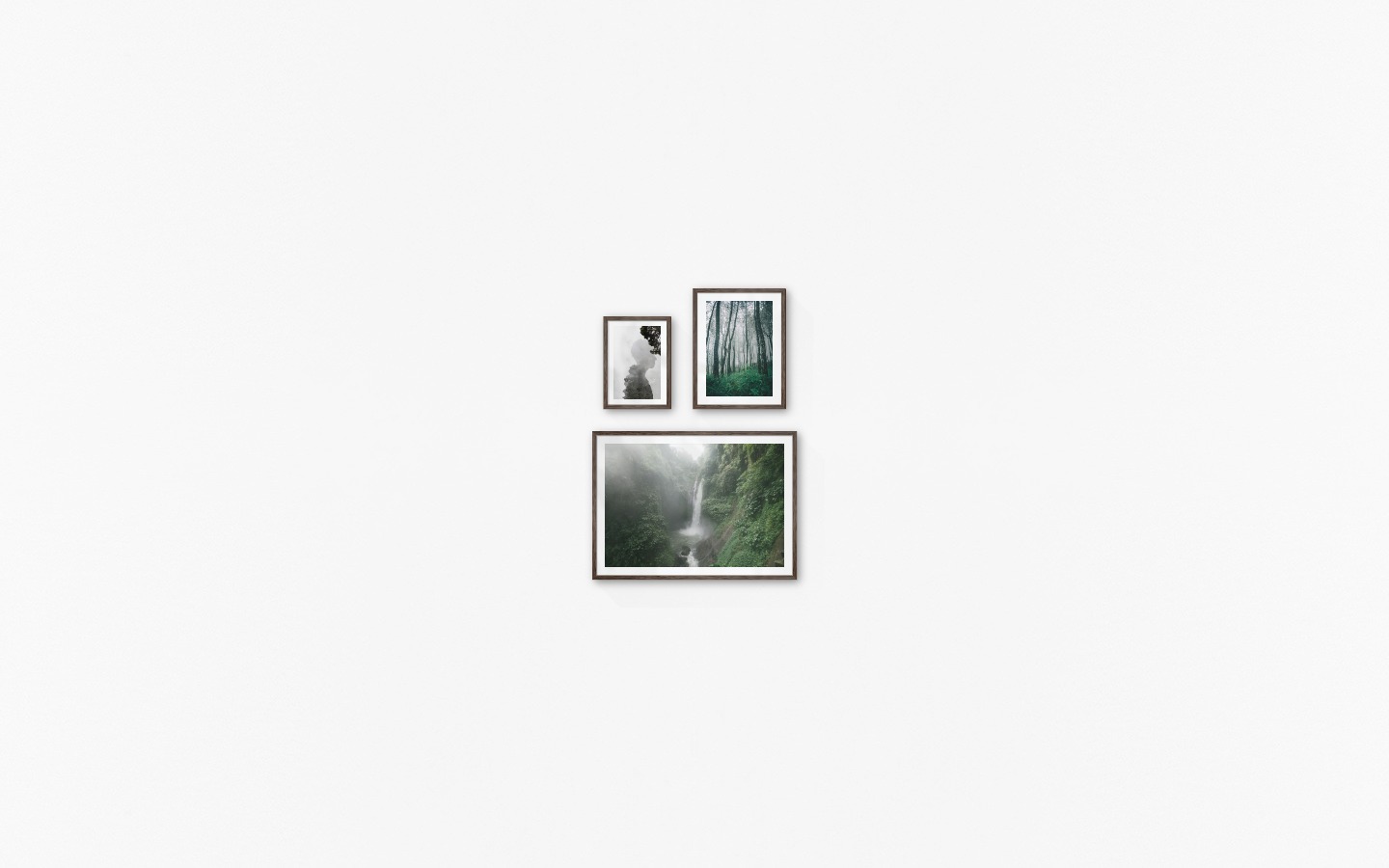 Gallery wall with picture frames in dark wood in sizes 21x30, 30x40 and 50x70 with prints "Silhouette and tree", "Tall trees" and "Waterfall in forest"