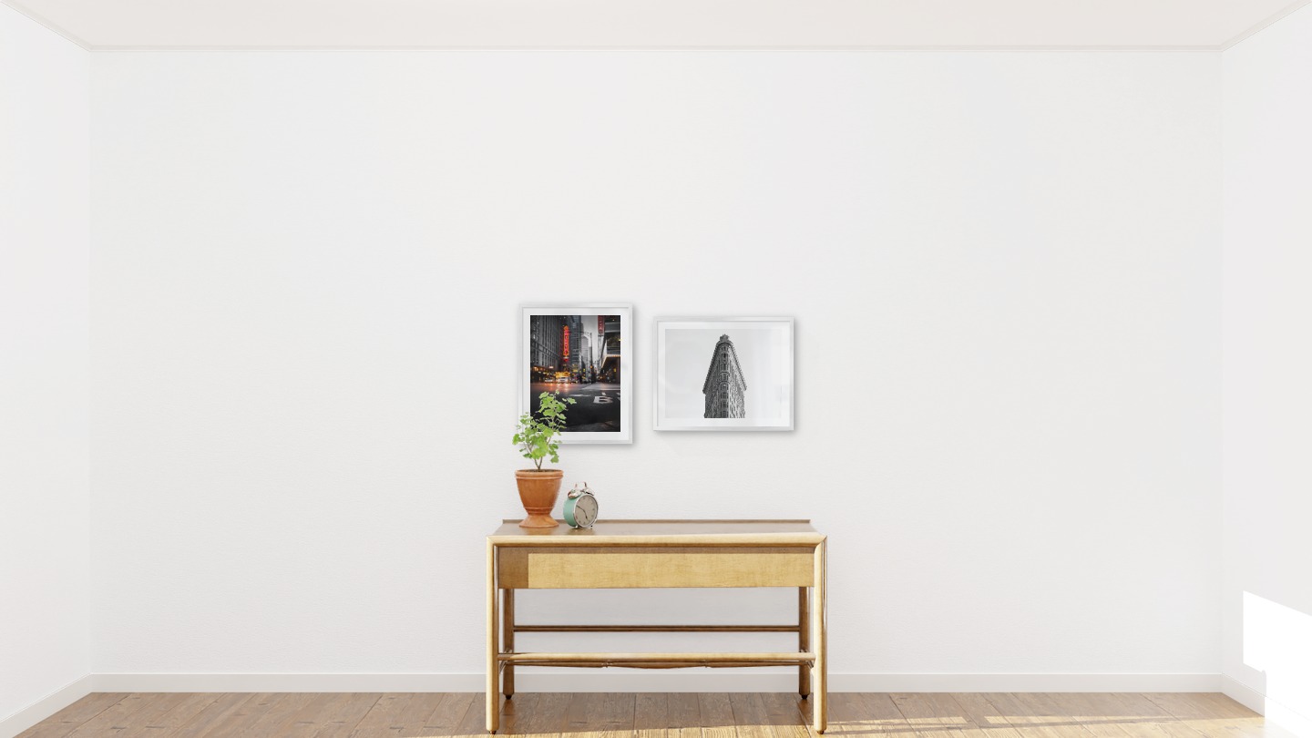 Gallery wall with picture frames in silver in sizes 40x50 with prints "Busy city center" and "Triangular building"