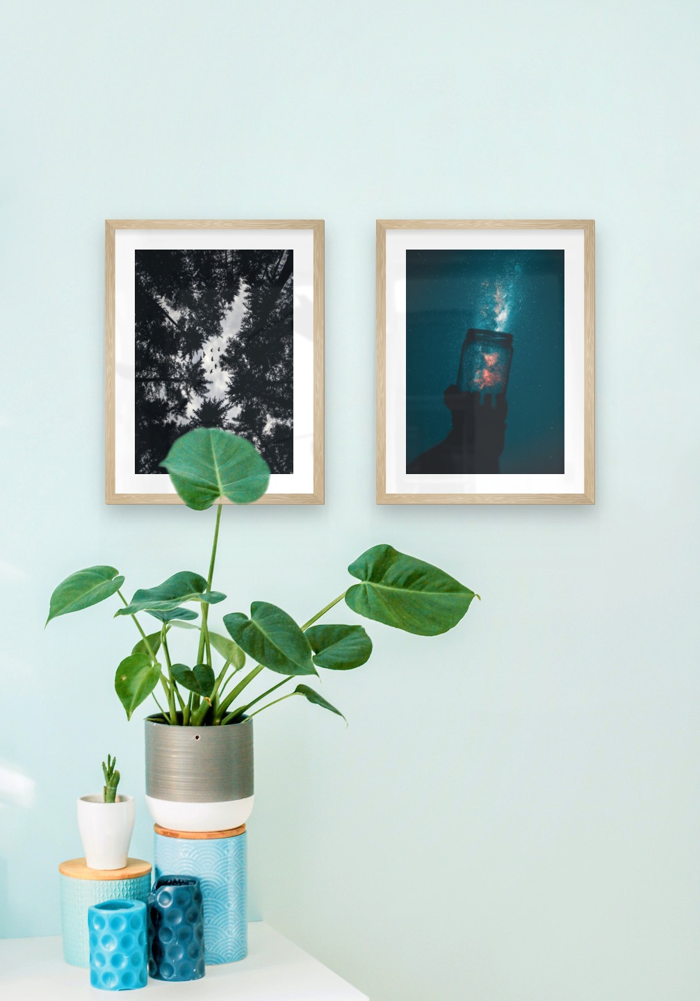 Gallery wall with picture frames in wood in sizes 30x40 with prints "Wooden tops and birds" and "Jar in front of space"