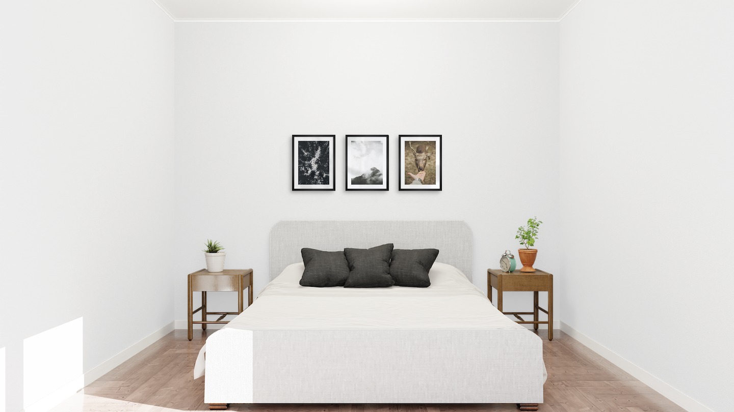 Gallery wall with picture frames in black in sizes 30x40 with prints "Wooden tops and birds", "Trees and mountains in fog" and "Feed a deer"