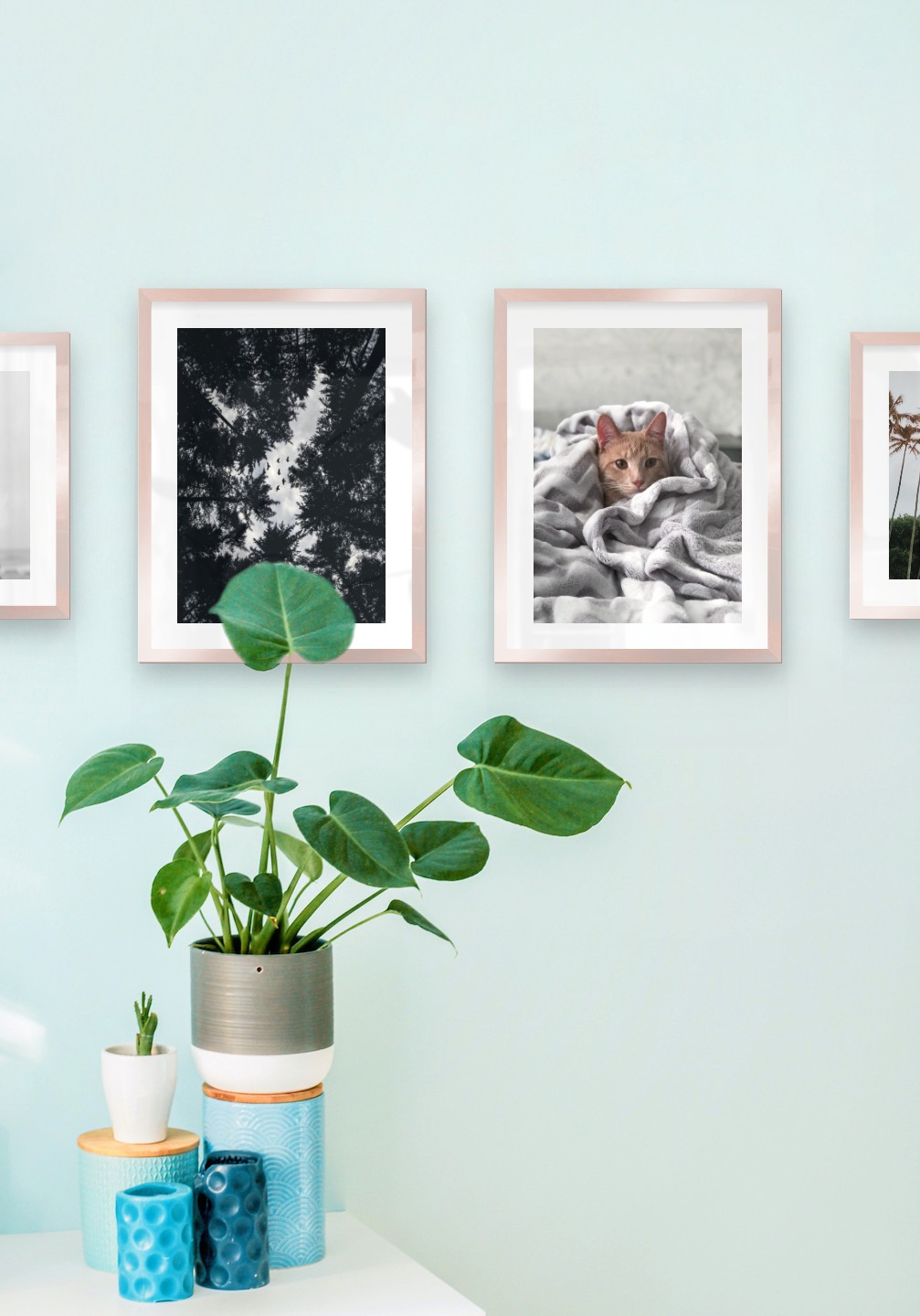 Gallery wall with picture frames in copper in sizes 30x40 with prints "Trees and silhouette", "Wooden tops and birds", "Cat in felt" and "Palm trees and mountains"