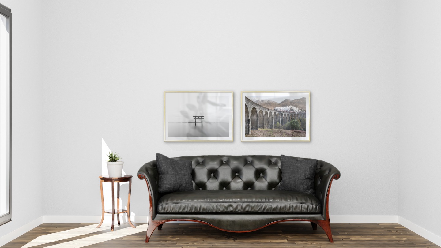 Gallery wall with picture frames in gold in sizes 50x70 with prints "Pillars in the water" and "Train on bridge"